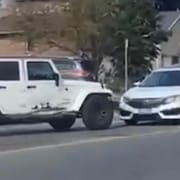Un Jeep à contresens face à un véhicule blanc. 