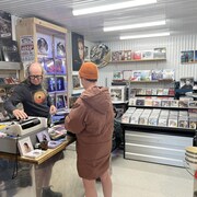 Une cliente achète un disque vinyle.