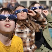 Des enfants avec des lunettes de protection pour regarder les éclipses. 
