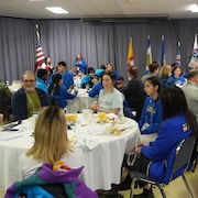 Des jeunes assis autour de tables avec leur uniforme le 14 mars 2024.