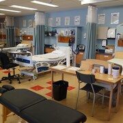 Des lits vides et du matériel médical dans une clinique aménagée dans un cégep.