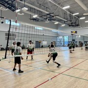 Des jeunes jouent au volleyball.