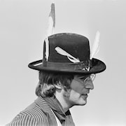 Le chanteur des Beatles porte un chapeau avec des plumes. 