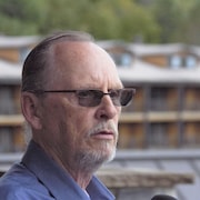 Un homme aux lunettes fumées.