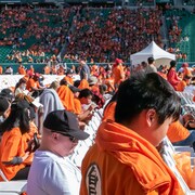 Des personnes portant des chandails oranges au stade Mosaïc.