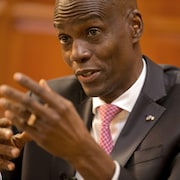 L'homme est assis et parle.