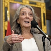 Une femme parlant devant un micro.