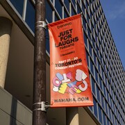 Une bannière du festival Just for Laughs 2023 à l'intersection des rues Yonge et Front, à Toronto.