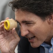 Justin Trudeau regarde dans un kaléidoscope.