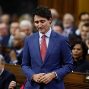 Justin Trudeau debout dans la Chambre des communes.