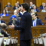Justin Trudeau vu de côté dans la Chambre des communes remplie d'élus.