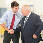 Justin Trudeau serre la main de Doug Ford en marge d'un point de presse à King City, près de Toronto, le 9 février 2024.