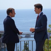 Emmanuel Macron et Justin Trudeau se regardent dans les yeux.