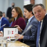 Le premier ministre Justin Trudeau ouvre un livre d'information intitulé "Réunion de travail des premiers ministres sur les soins de santé" alors qu'il rencontre les premiers ministres du Canada à Ottawa le mardi 7 février 2023 à Ottawa. La première ministre du Manitoba, Heather Stefanson, est assise à sa droite et le premier ministre du Québec, François Legault, à sa gauche.