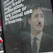 Une pancarte vandalisée de Justin Trudeau avec des cornes et une moustache en brosse à dents ajoutées au marqueur. 