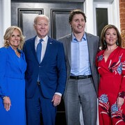 Quatre personnes posent sur le perron de la résidence du premier ministre, Rideau Cottage, à Ottawa.