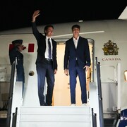 Justin Trudeau et son fils Xavier en haut d'un escalier pour monter dans un avion.