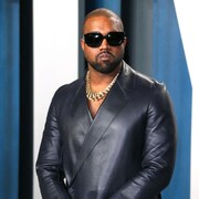 Kanye West porte une veste en cuir et des lunettes de soleil. 