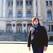 Karen Nurkowski pose à l'extérieur devant l'assemblée législative de la Saskatchewan, à Regina.