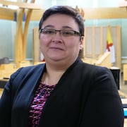 Une femme se tient debout à l'Assemblée législative du Nunavut, à Iqaluit.