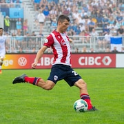 Un joueur de soccer manie le ballon pendant un match.