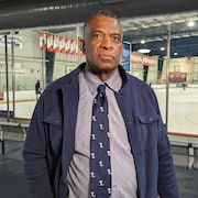 Un homme devant une patinoire intérieure.