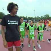 Kayla Alexander marche aux côtés de jeunes basketteuses. 