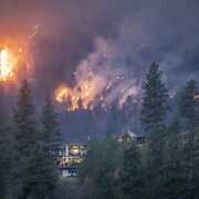 Un feu de forêt brûle à proximité de propriétés à Kelowna, le 18 août 2023. 