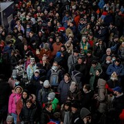 Une foule massée sur un quai d'embarquement.