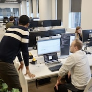 Deux hommes au travail devant un ordinateur.