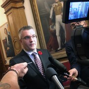 Kris Austin en mêlée de presse à l'Assemblée législative du Nouveau-Brunswick.
