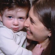 Alanna Handelman porte son fils dans ses bras.