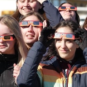 Un groupe de jeunes filles portent des lunettes de protection pour regarder l'éclipse solaire du 8 avril 2024. 