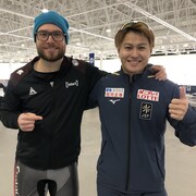 Les patineurs de vitesse Laurent Dubreuil et Yuma Murakami posent pour la caméra en souriant.