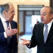 MM. Lavrov et Cavusoglu discutent en marchant.