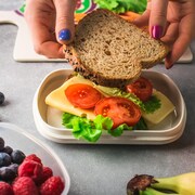 Une personne fait un sandwich pour une boîte à lunch.