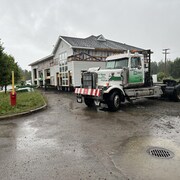 Un camion lourd se trouve devant deux édifices.