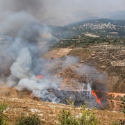 De la fumée et des flammes dans un champ à la suite de bombardements israéliens au Liban le 4 août 2021.