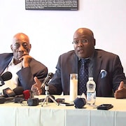 Des hommes noirs lors d'une conférence de presse.