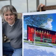 Lilie Bergeron, directrice générale de Côté scène pose aux côtés d'une image de la future salle de spectacle.