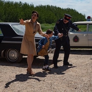 Image de la série, où une petite fille est tiraillée de part et d'autre par une femme et un policier.
