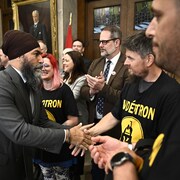 Le chef du NPD, Jagmeet Singh, salue un groupe d'hommes et de femmes.