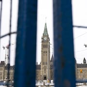 La tour de la Paix du Parlement est visible entre des panneaux de clôtures temporaires.