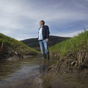 Portrait de Louis Robert, dans un champ en partie inondé.