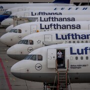Des avions de Lufthansa alignés sur la piste d'un aéroport.