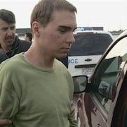 Luka Rocco Magnotta lors d'un transfert avec les policiers.