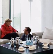 Montage photo montrant Emmanuel Macron devant Angela Merkel.