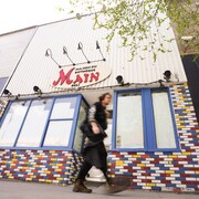 Un homme marchant devant la façade d'un restaurant