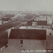 Photo d'époque montrant des habitation bordant une large rue. 