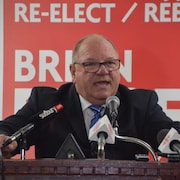 Un homme derrière des micros.